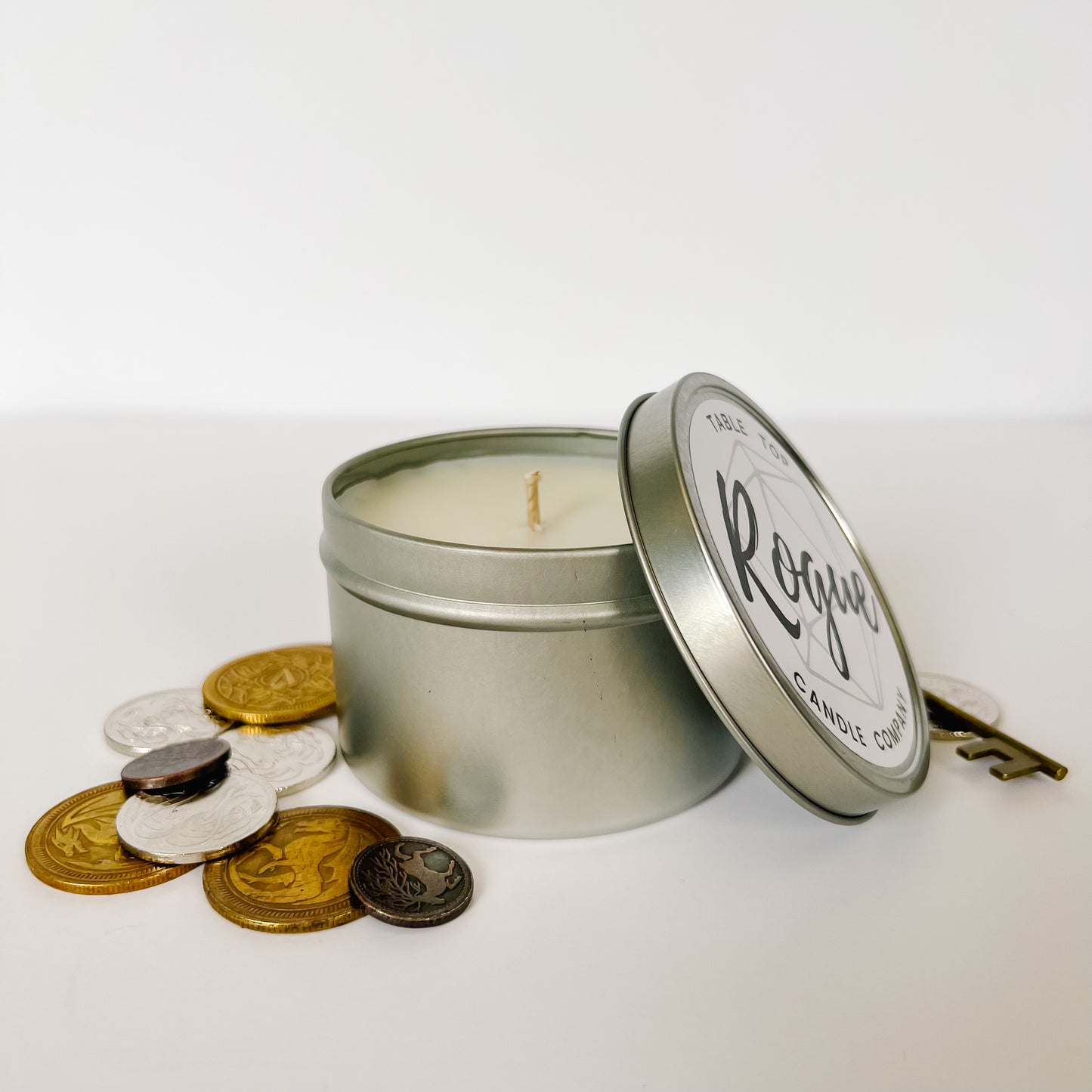 Our 8 ounce candle. In our Rogue scent. It is surrounded by coins and a key